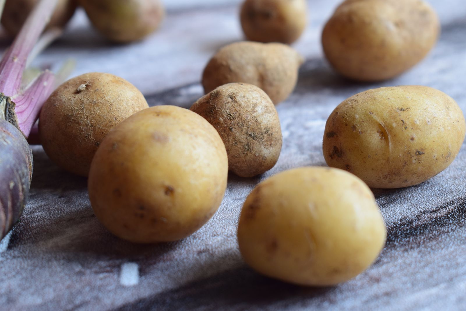 Ongeschilde aardappelen op een houten ondergrond Ongeschilde aardappelen op een houten ondergrond