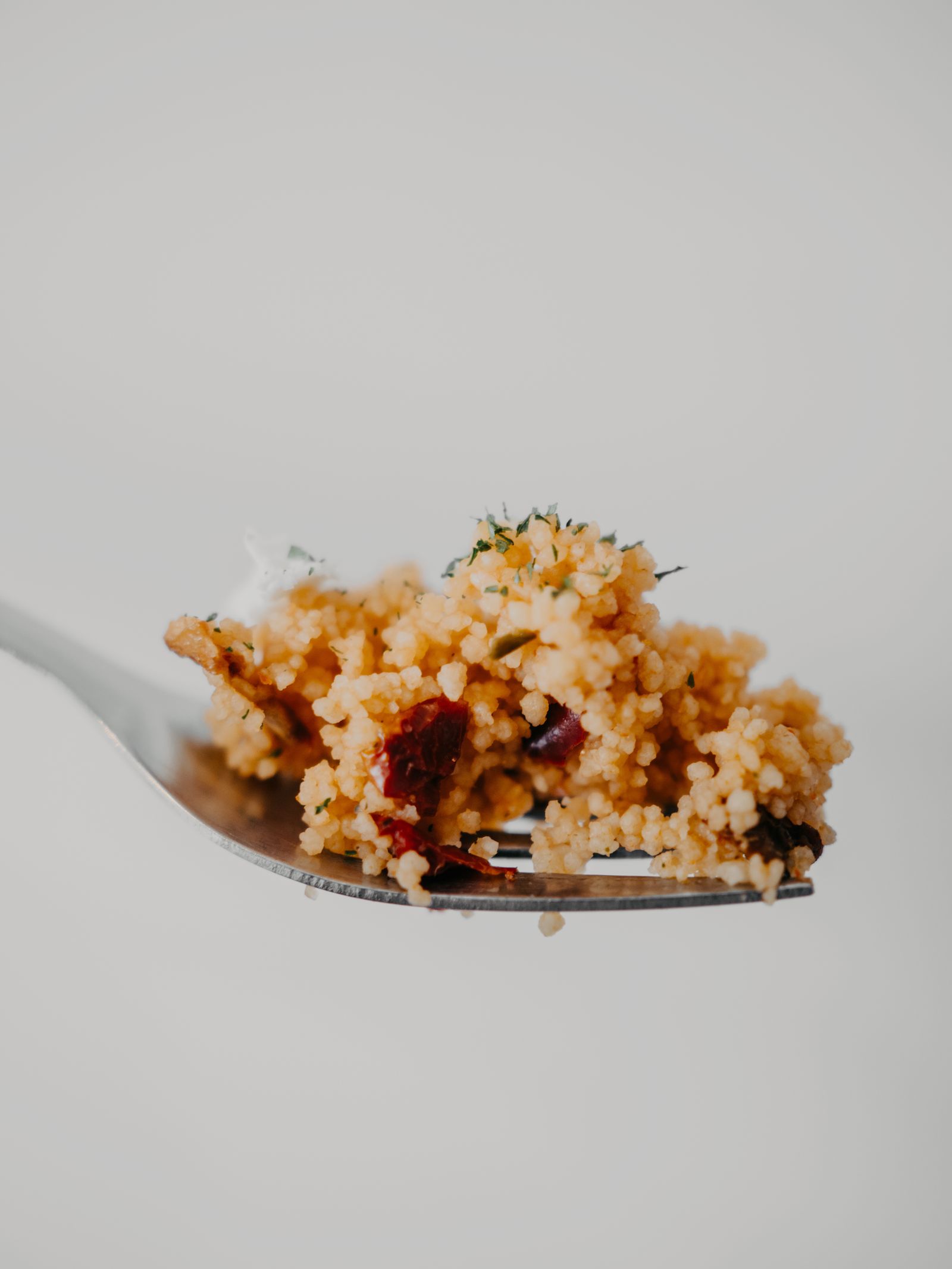 Couscous met groente op een vork Couscous met groente op een vork