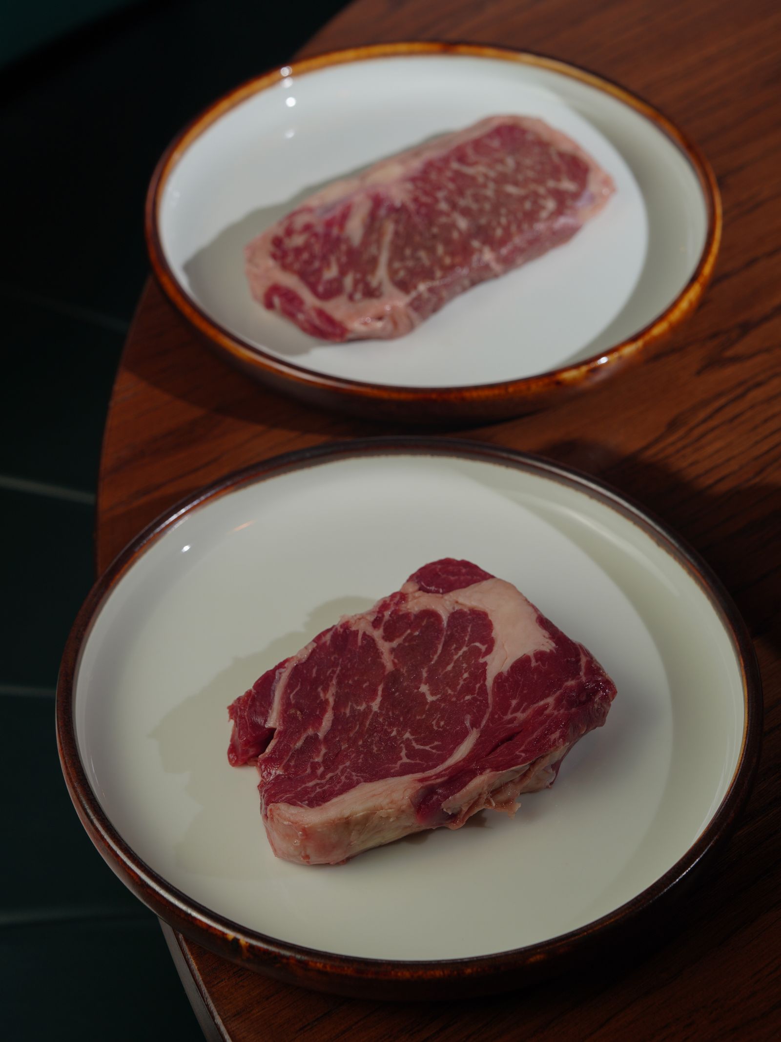 Twee rauwe rundersteaks op borden
